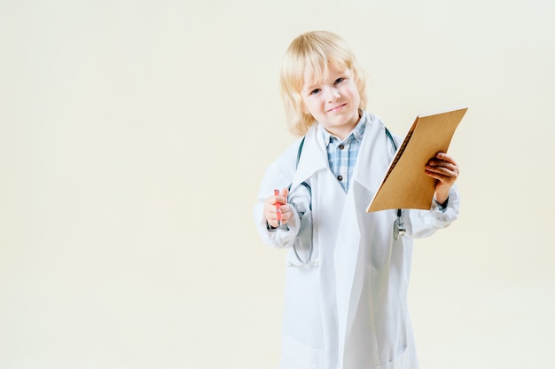 Petit garçon blond blond en tenue de médecin