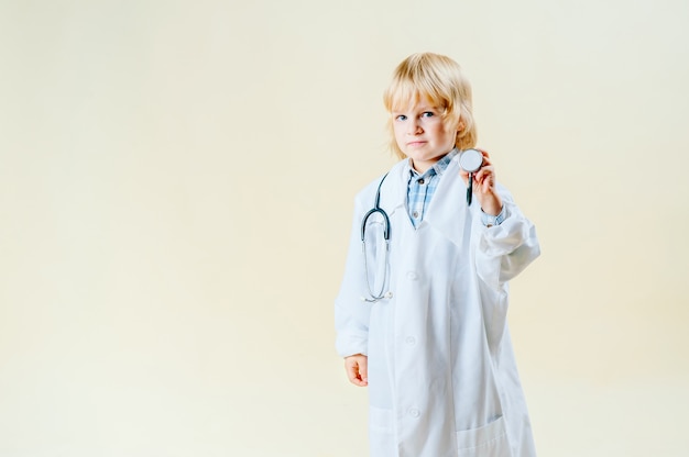 Petit garçon blond blond en tenue de médecin