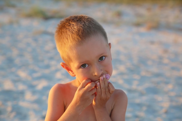 Petit garçon avec des bonbons sur la mer