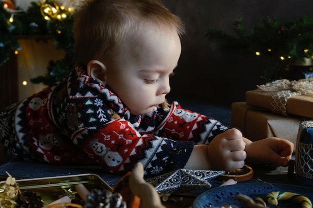 Petit garçon avec boule de Noël à la maison