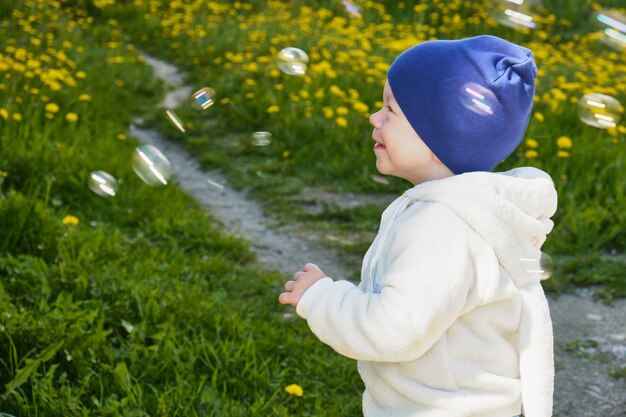 Petit garçon avec des bulles de savon dans le parc