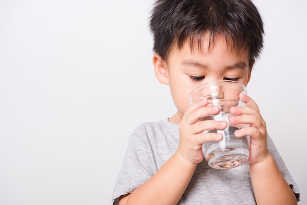 Petit garçon buvant de l'eau en verre