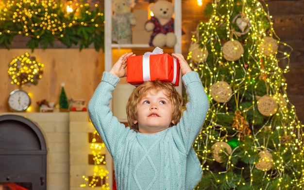 Petit garçon avec un cadeau de Noël sur la tête