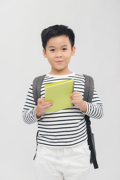 Petit garçon avec un cahier et un sac à dos