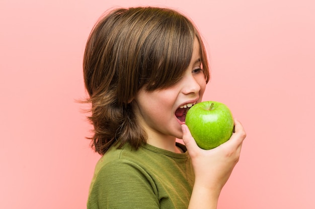 Petit garçon caucasien tenant une pomme