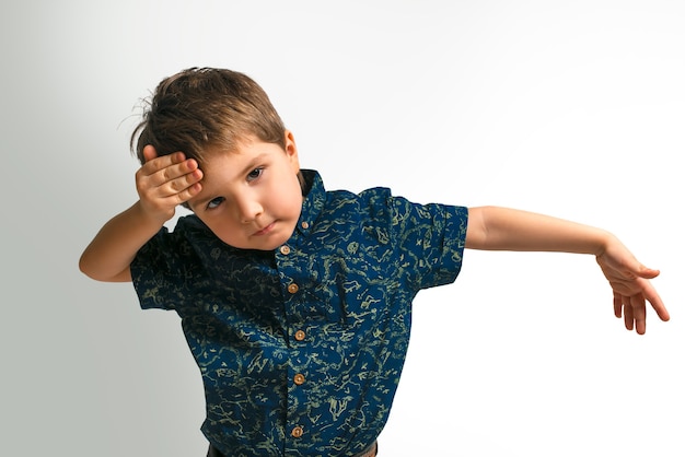 Un petit garçon en chemise sur fond blanc