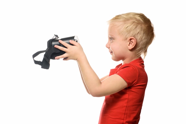 Petit garçon en chemise rouge détient une réalité virtuelle.