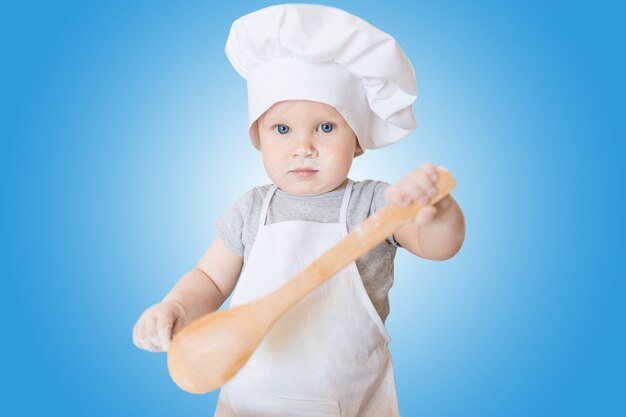 Le petit garçon en costume de cuisinier sculpte la pâte Petit marmiton prépare le dîner en costume de chef