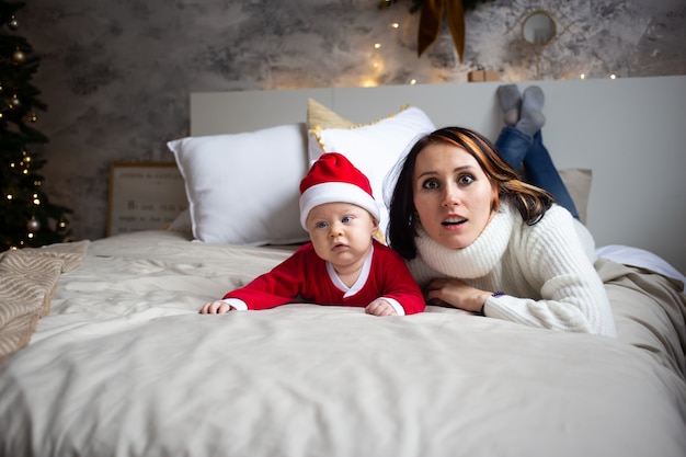 Petit garçon avec costume de père Noël à la maison