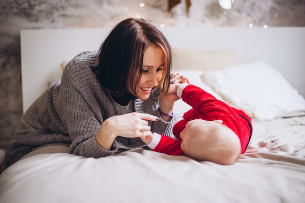 Petit garçon avec costume de père Noël à la maison