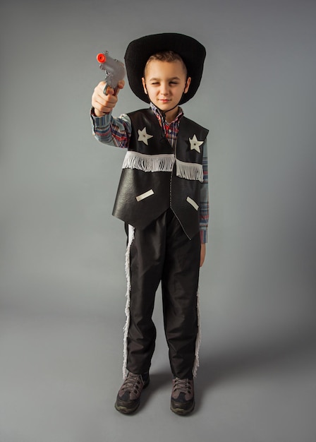 Le petit garçon en costume de shérif en pied