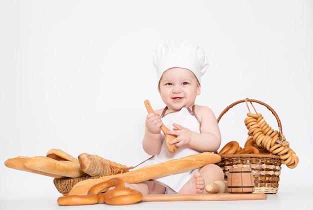 Petit garçon dans une casquette de cuisinier et avec du pain petit chef drôle