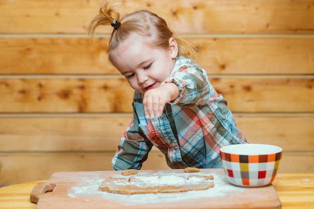 Petit garçon dans la cuisine aidant à cuisiner en jouant avec de la farine