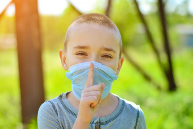 Un petit garçon dans un masque médical.