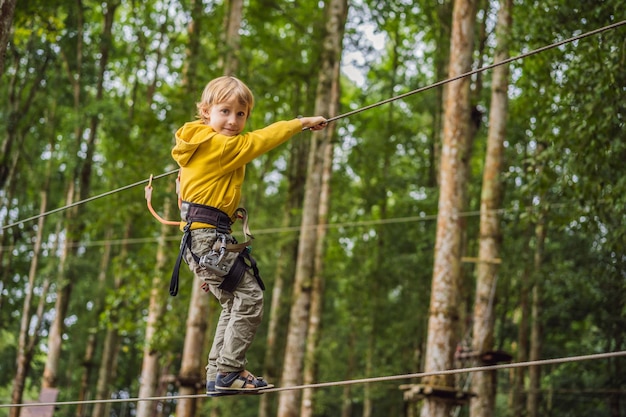 Petit garçon dans un parc à cordes Récréation physique active de l'enfant à l'air frais dans le parc Entraînement pour les enfants