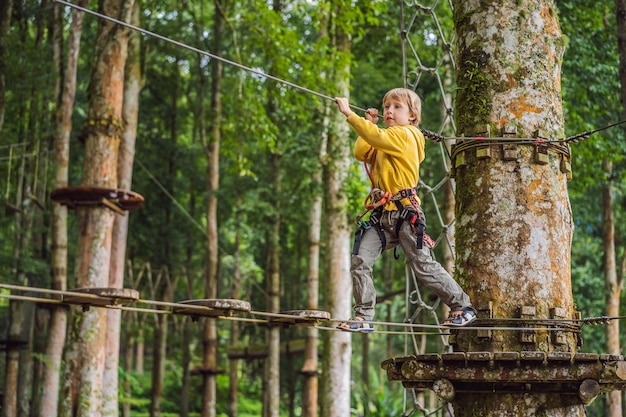 Petit garçon dans un parc à cordes Récréation physique active de l'enfant à l'air frais dans le parc Entraînement pour les enfants