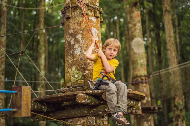 Petit garçon dans un parc à cordes Récréation physique active de l'enfant à l'air frais dans le parc Entraînement pour les enfants