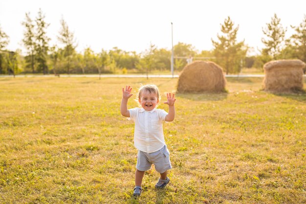 Petit garçon dans la rue, à la campagne. Tout-petit jouant à des jeux actifs à l'extérieur. Enfance, insouciance, jeux d'enfants, garçon, air frais, repos des enfants actifs. La notion d'enfance