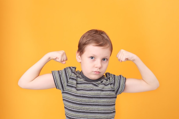 Petit garçon démontrant ses muscles