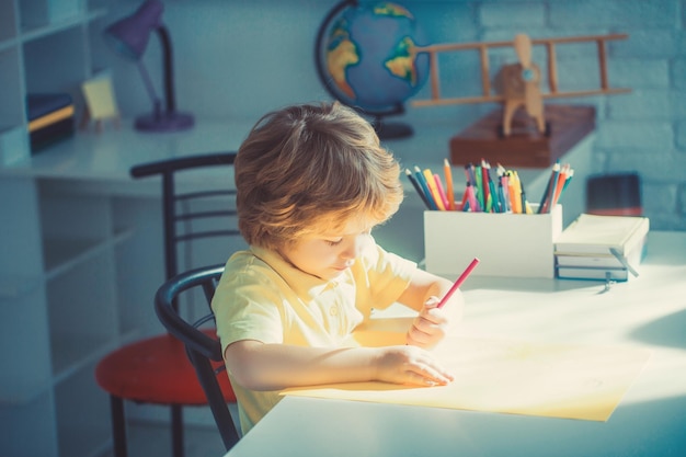 Petit garçon dessinant dans la salle d'éducation et de garderie