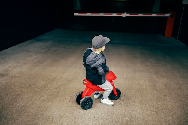 Un petit garçon devant le garage sur véhicule