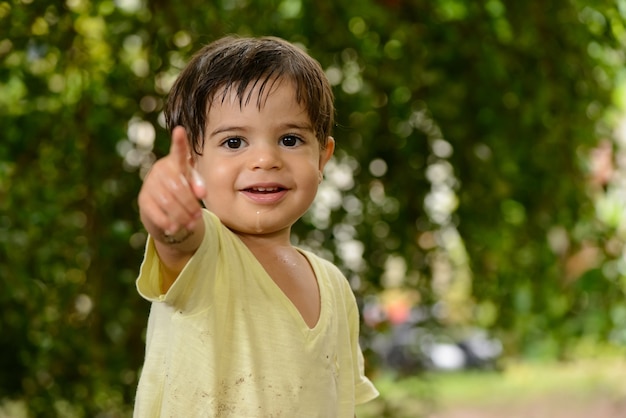 Petit garçon de dix-huit mois souriant et pointant son doigt