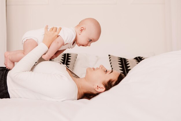 Petit garçon drôle d'enfant mignon, la mère joue avec son fils, lance le bébé. Rire souriant espiègle