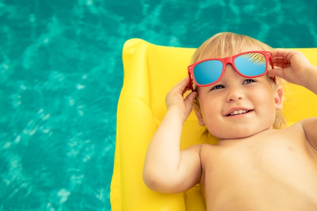 Petit garçon drôle en vacances d'été. Enfant s'amusant dans la piscine