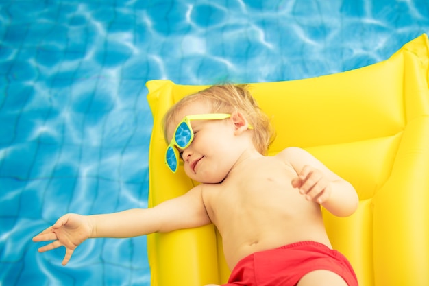 Petit garçon drôle en vacances d'été. Enfant s'amusant dans la piscine