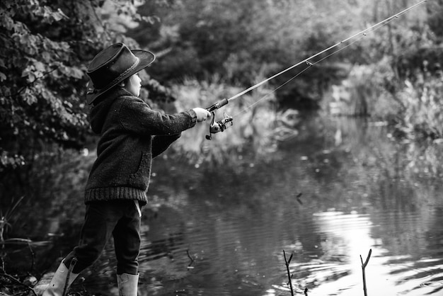 Petit garçon enfant attrapant un poisson Enfant avec une canne à pêche au lac