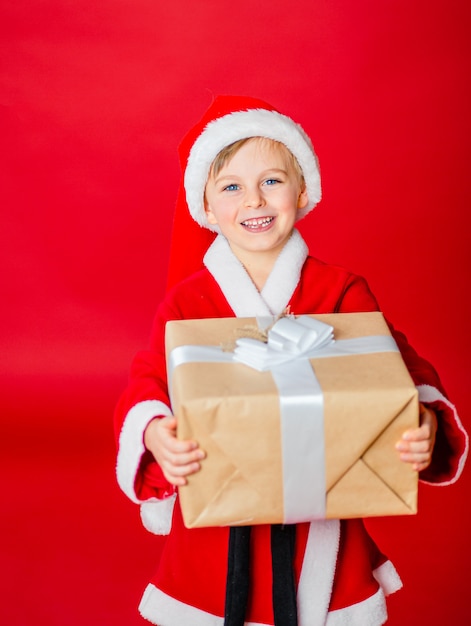 Petit garçon enfant habillé en père Noël. Achat de noël. Cadeau de Noël. Enfance