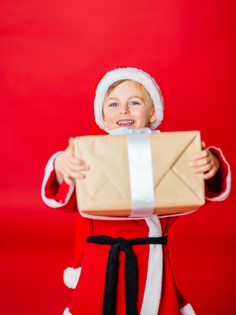 Petit garçon enfant habillé en père Noël. Achat de noël. Cadeau de Noël.