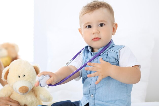 Petit garçon enfant avec sa mère à l'examen de santé au cabinet du médecin