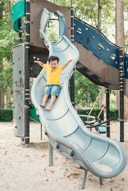 Photo le petit garçon est sur le terrain de jeu abaisse le tuyau, été, bonheur, vacances