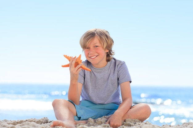 Petit garçon avec une étoile de mer