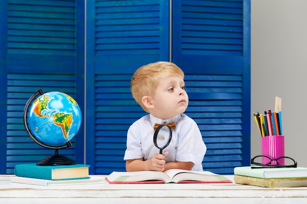 Un petit garçon étudie la géographie avec un globe terrestre