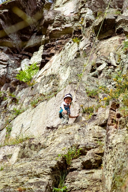 Petit garçon fait de l'alpinisme dans la nature