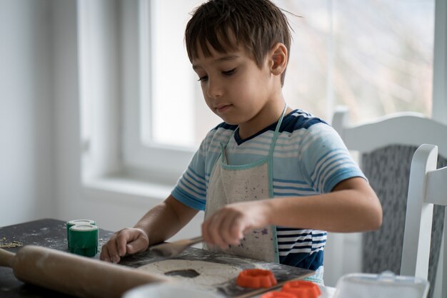 Petit garçon fait de la pâte pour un délicieux bonbon