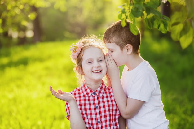 Petit Garçon Et Fille Chuchote.