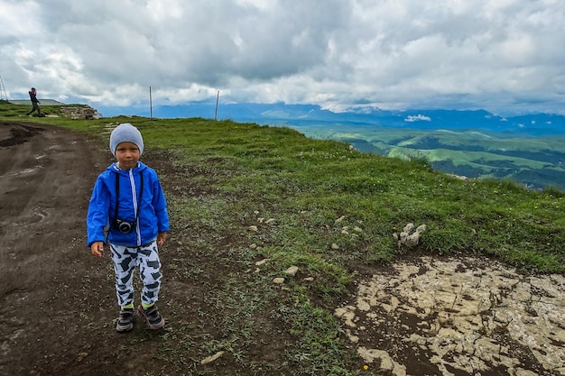 Un petit garçon sur fond de montagnes et du plateau de Bermamyt en Russie juin 2021