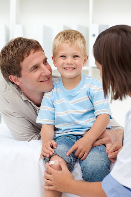 Petit garçon avec un genou égratigné avec son père en remorque