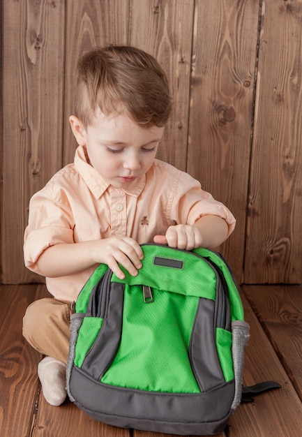 Petit garçon avec grand sac d'école