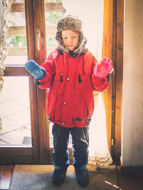 Petit garçon en habit de neige faisant des expressions drôles