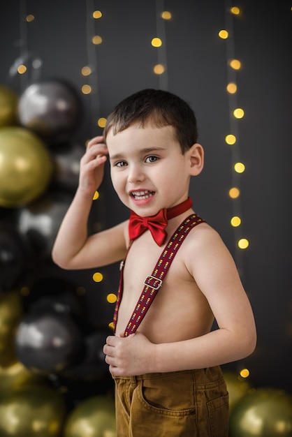 Un petit garçon heureux dans un studio sombre