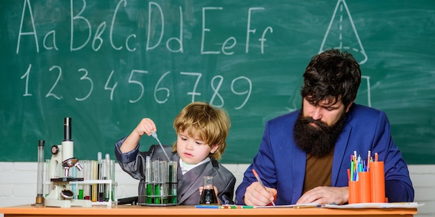 Petit garçon avec l'homme enseignant. Formule. expériences en laboratoire de chimie organique. fils et père à l'école. Sagesse. Retour à l'école. recherche en biotechnologie. L'éducation vient de l'intérieur.