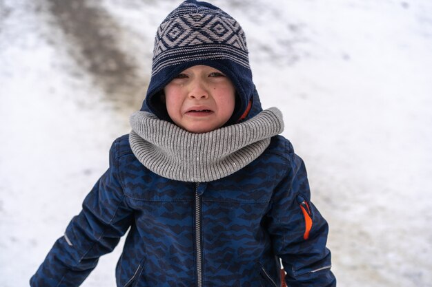 Petit garçon hurle et pleure. Émotions. Garçon en vêtements d'hiver