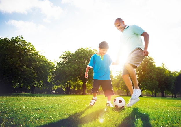 Petit garçon jouant au football avec son père.