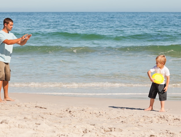 Petit garçon jouant au frisbee avec son père