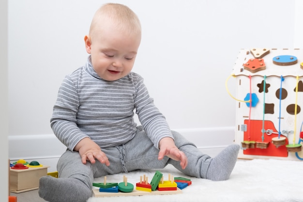 Petit garçon jouant dans le conseil occupé et jouets en bois. développement de la petite enfance.