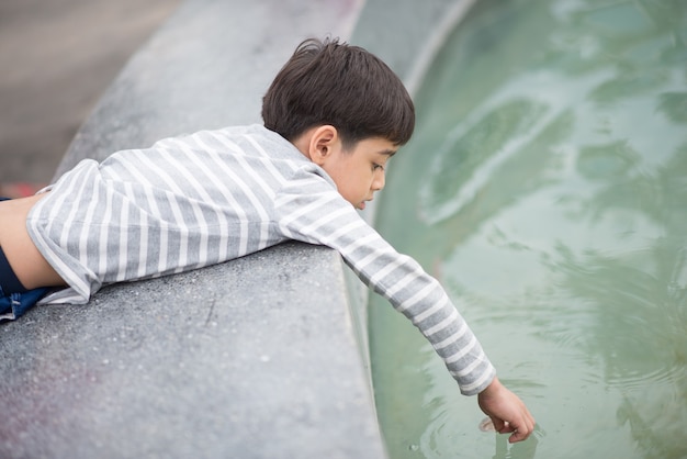 Photo petit garçon jouant dans l'eau